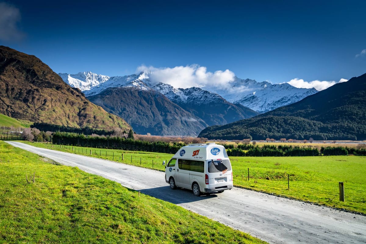 Euro Campers campervan on a country road with snowy mountains in New Zealand
