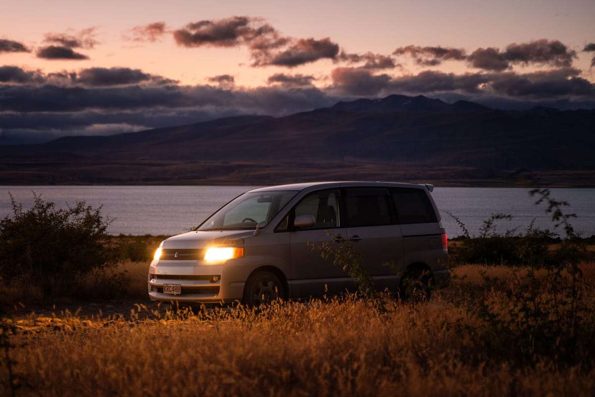 Campervan Village campervan by a lake at sunset in New Zealand